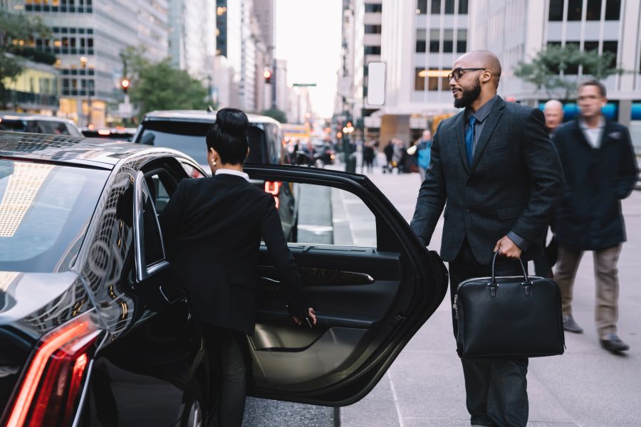 executive arrival woman opening car door for man 2026 03 24 23 20 37 utc 1